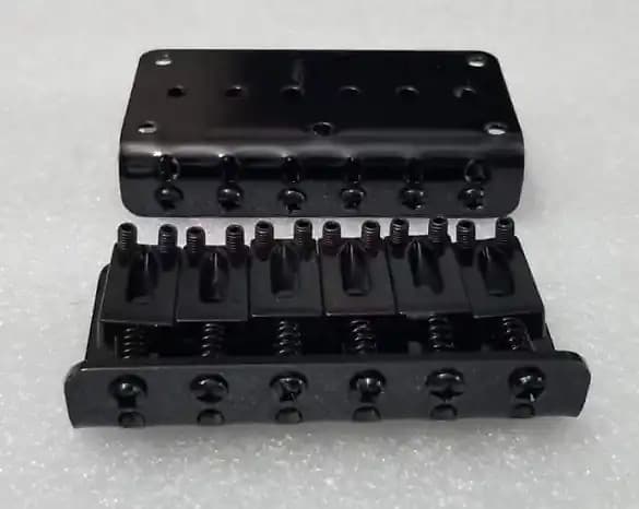 Black hardtail guitar bridge with 6 saddles, springs, and mounting plate