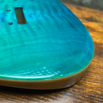 Teal glossy Tele-style guitar body side with smooth contoured edge