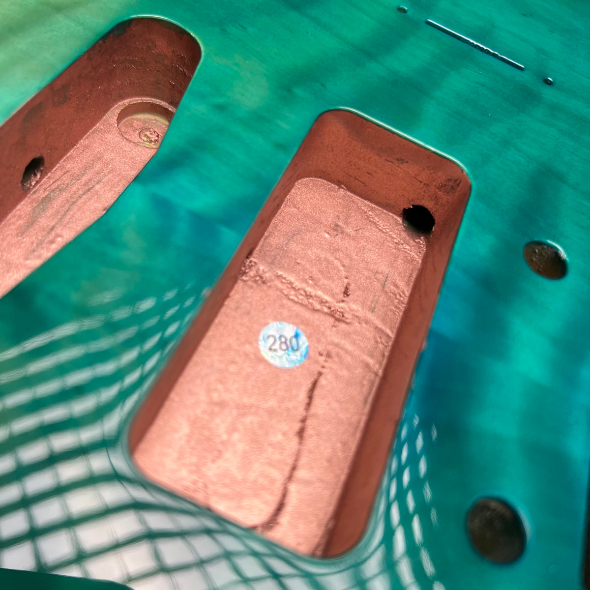 Teal glossy guitar body top with two P90 routes, screw holes, and copper shielding
