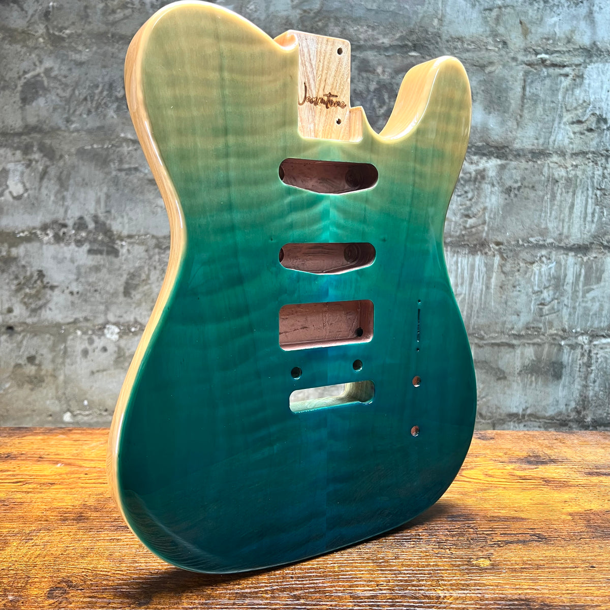 Teal glossy Tele-style guitar body back with routed cavities and mounting screw holes