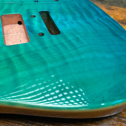 Teal glossy guitar body top with pickup cavities, mounting holes, and routed channels