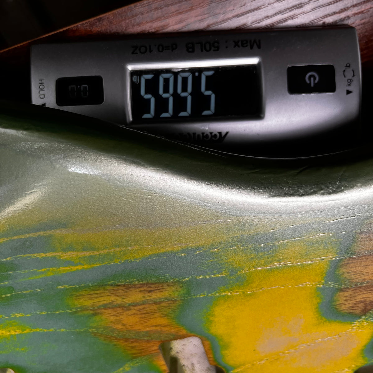 Close-up of green and yellow bass body with control cavity, thermometer display on top