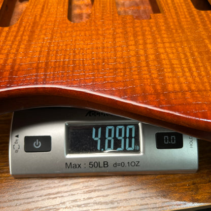 Flamed maple Strat-style guitar body in vintage amber with visible pickup cavity routing