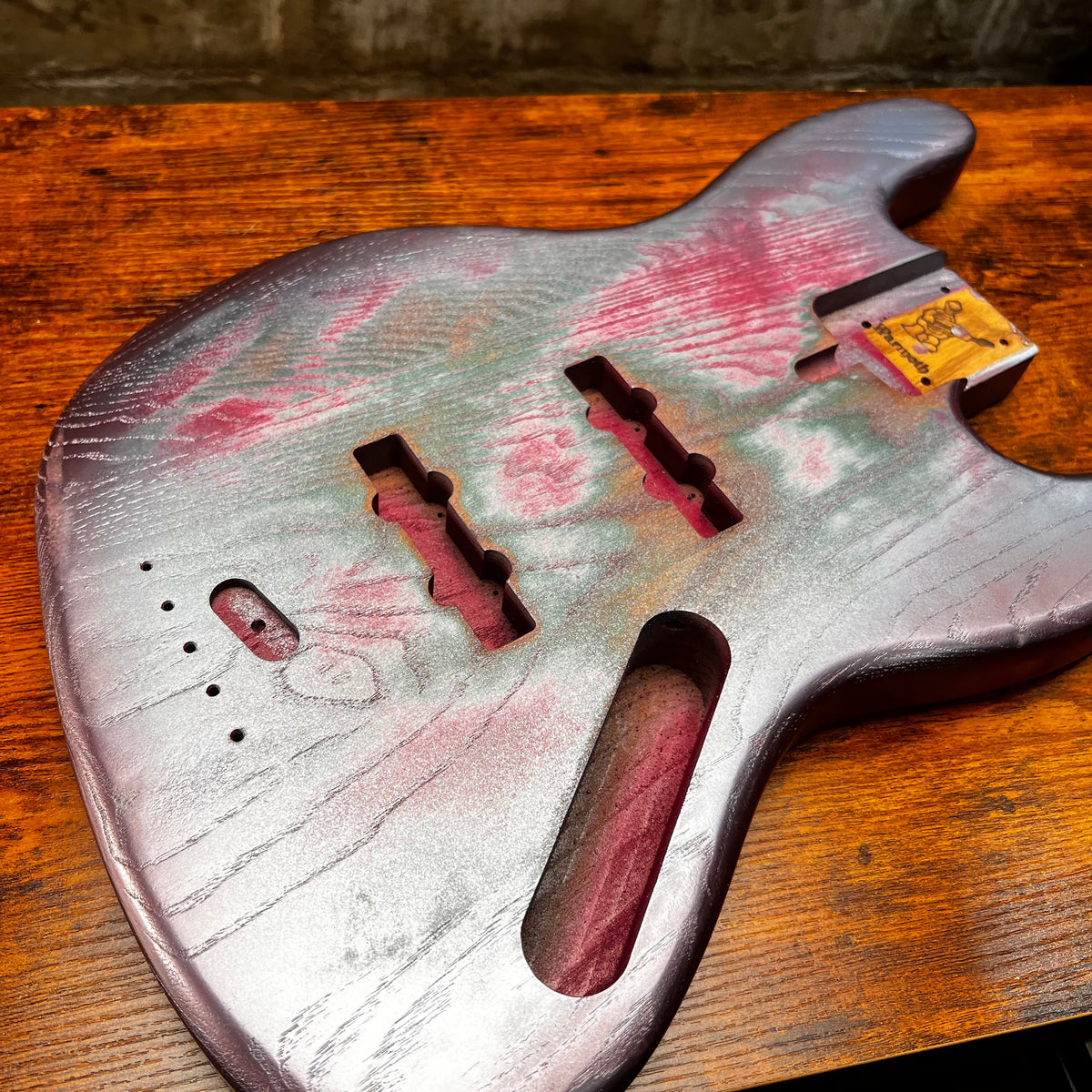 Replacement J Bass body with pink and green relic finish, pickups and neck mounting openings