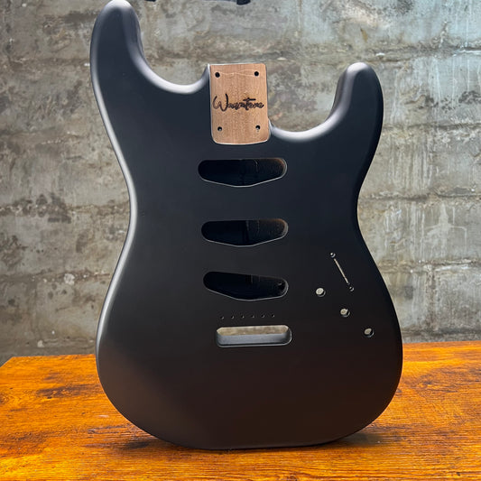 Matte black Strat-style guitar body with Warmtone neck plate, routed controls and holes