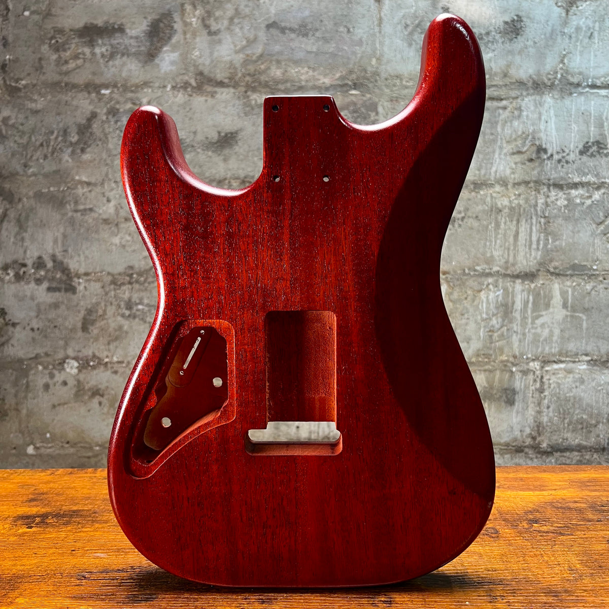 Strat-style guitar body underside in vintage amber with control cavity and bridge cutout