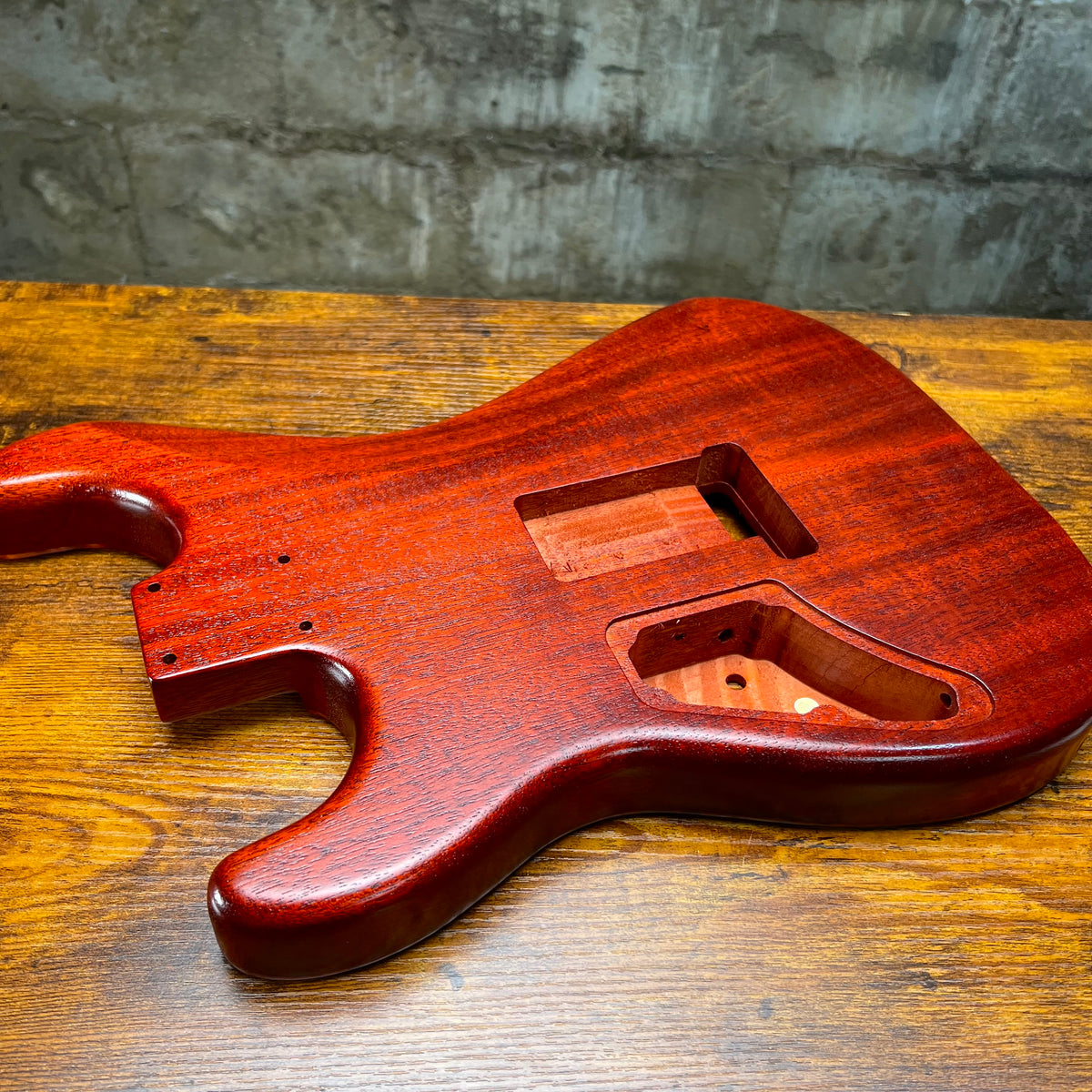 Flamed maple Strat-style guitar body angled view with neck pocket and cutouts