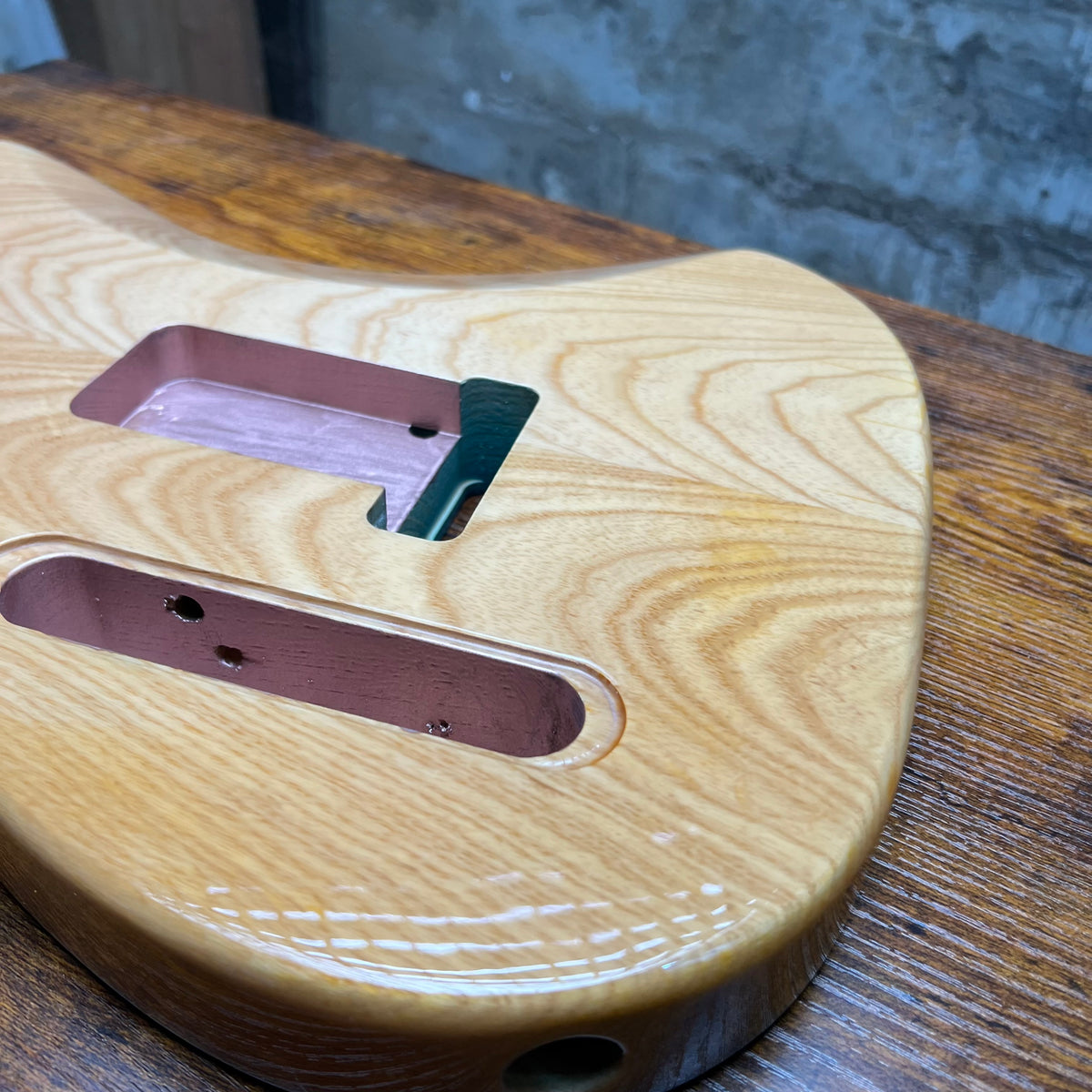 Flamed maple Tele-style guitar body with routed pickup openings and neck pocket
