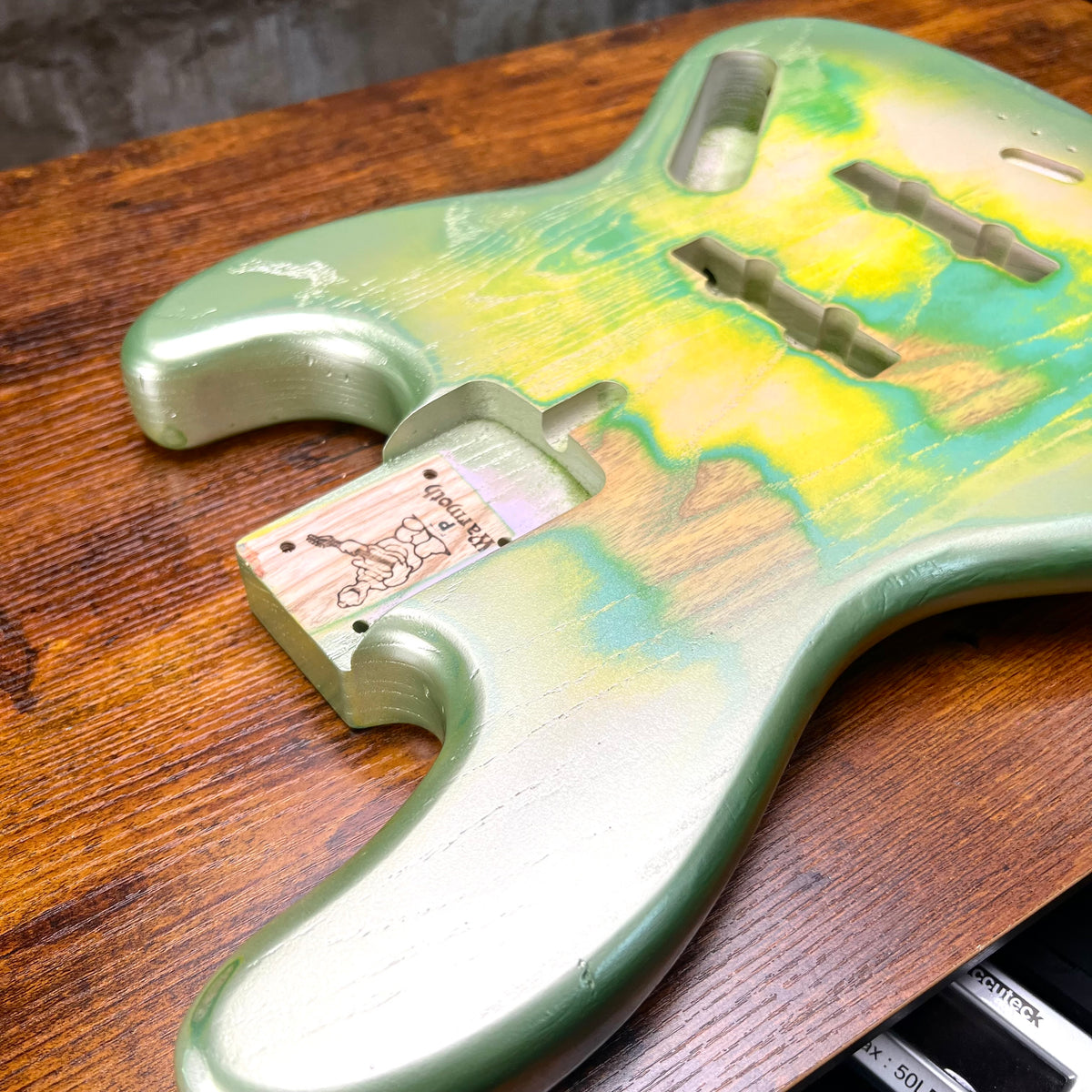 Green and yellow nitro relic bass body with routed cavities and control holes