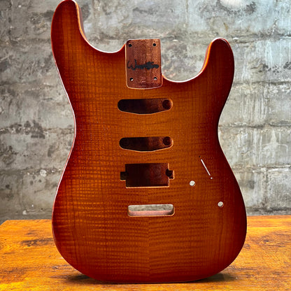 Vintage amber Strat-style guitar body front with pickguard holes, control opening, and jack plate