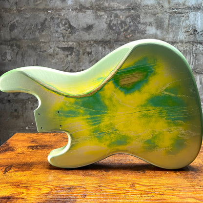 Sunburst-style green and yellow bass body, side profile with hardware holes