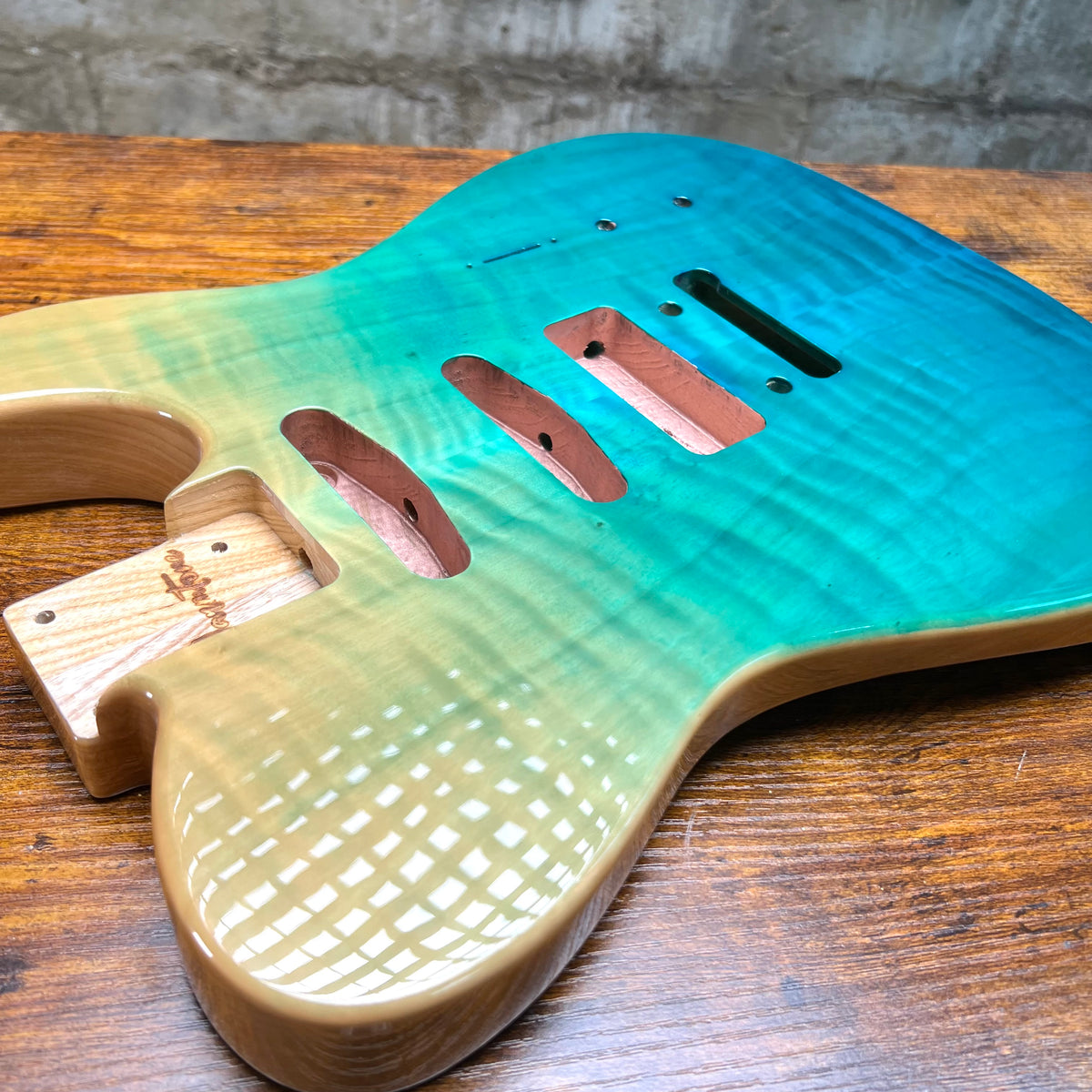 Tele-style guitar body with two P90 openings, neck pocket, and visible wood base