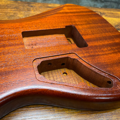 Strat-style guitar body detail showing humbucker-style cavity and wiring channel cutouts